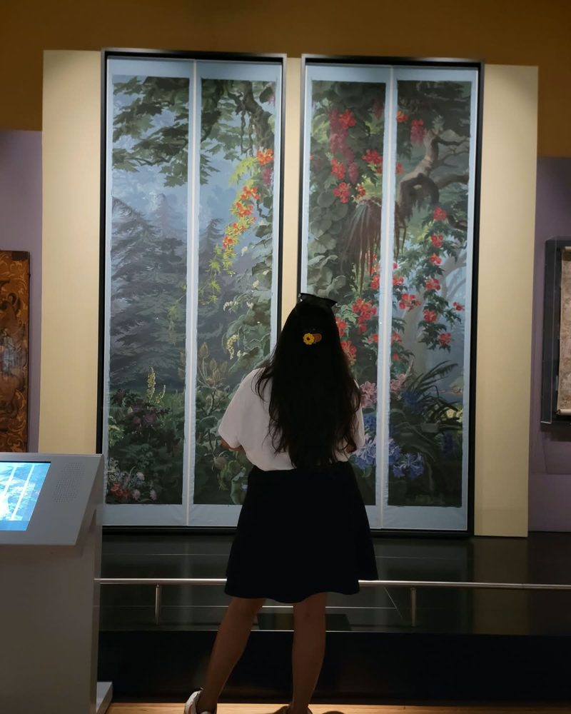 Muskan looking at a botanical mural in a museum